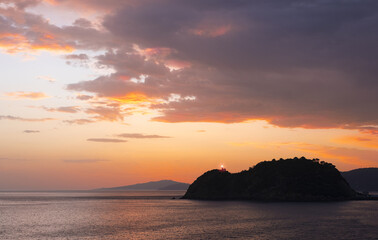 Naklejka na ściany i meble Lighthouse and sunrise in Getaria and the Cantabrian Sea, Basque Country coast.