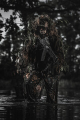 Eastern special forces soldier with rifle in the jungle - obrazy, fototapety, plakaty