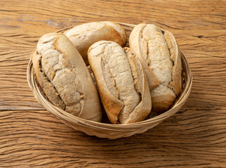 Whole grain french bread, salt bread or pistolet in a basket over wooden table