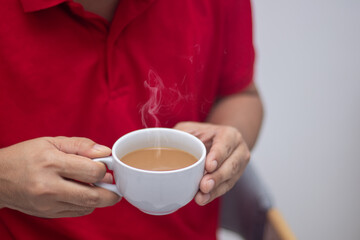 man holding a hot cup of coffee