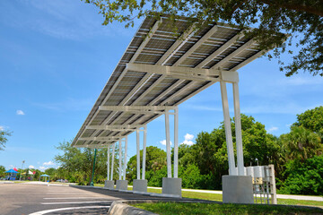 Solar panels installed over parking lot canopy shade for parked cars for effective generation of clean energy