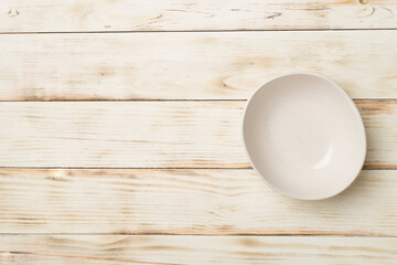 Empty round plate on wooden background, top view