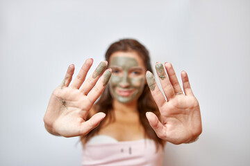 The girl uses blue clay for face care. Beauty concept, skin care cosmetics, facelift. Beauty salon. Wrinkle removal.