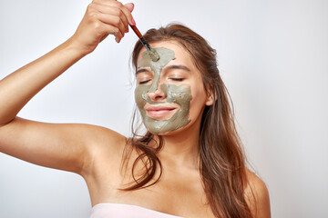 The girl uses blue clay for face care. Beauty concept, skin care cosmetics, facelift. Beauty salon....