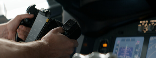 CU Commercial aircraft pilots controlling the yoke of the airplane during the flight at high altitude. View from inside the cabin. Real aircraft, daytime shot