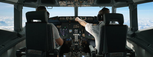 Commercial aircraft pilots adjusting flight parameters of the plane during the flight at high...