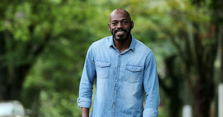 Happy African person celebrating good news holding smartphone smiling