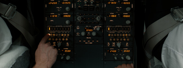CU Commercial aircraft pilots adjusting radio channel parameters during the flight at high...