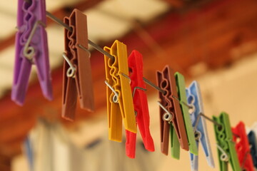 Colorful pegs on a white hanging rope