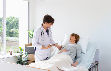 Obraz premium male doctor consulting senior old patient. Professional physician wearing white coat talking to mature woman.