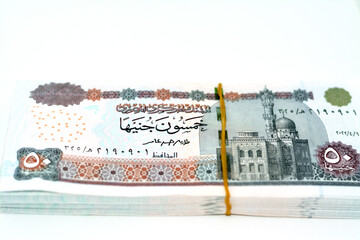 A pile of Egyptian money banknotes of 50 LE fifty pounds series 2022 features Abu Hurayba Mosque on obverse and image of temple of Edfu, winged scarab and a pharaonic boat on reverse isolated on white - obrazy, fototapety, plakaty