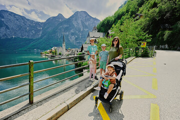 Mother with four kids against beautiful scenic landscape over Austrian alps lake in Hallstatt, Austria.