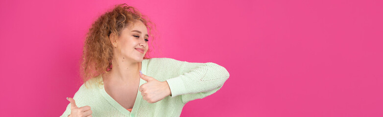 Close-up portrait of attractive surprised girl, showing thumbs up gesture. Success luck concept.