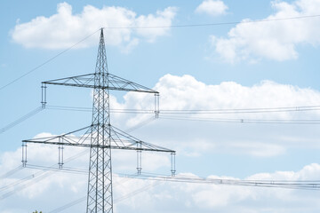 Electricity pylon for over land power transmission of high voltage in front of blue sky