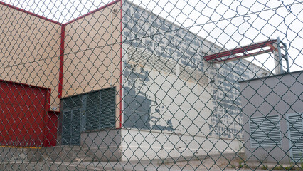 Callej&oacute;n industrial tras valla de alambrada