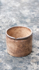 Vaso de barro marrón sobre superficie de piedra oscura