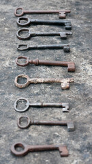 Fila de llaves antiguas oxidadas sobre mesa de piedra