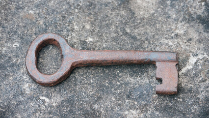 Llave antigua oxidada sobre mesa de piedra