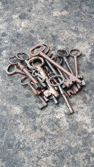 Montón de llaves antiguas oxidadas sobre mesa de piedra