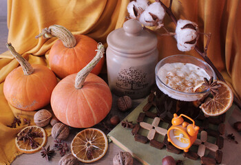 Composition of pumpkin, walnuts, coffe and orange slices photo. Autumn still life with rustic orange vegetables. Seasonal organic food. Background for fall card or banner.