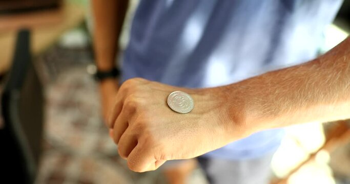 Man flipping silver coin with hand to make right choice closeup 4k movie slow motion