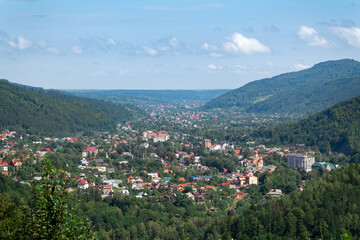 a town surrounded with a green forest and mountains