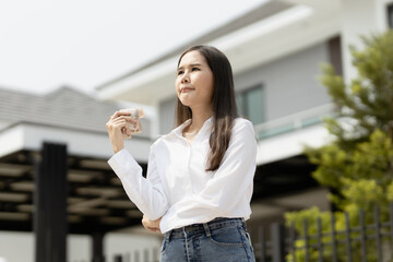 home, money, people concept. Smiling young successful happy business woman holding dollar cash money in hand over house and home background