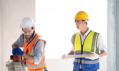 Engineer wearing safety vest controlling machine working with assistant engineer worker checking...