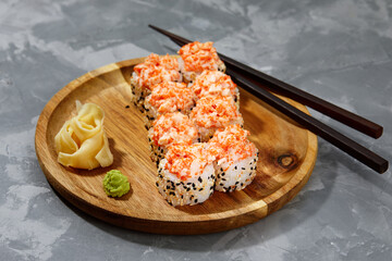 Warm rolls with tuna, salmon, perch, eel, tobiko caviar, nori, rice, cucumber on a black background.