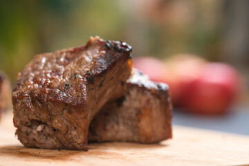 Closeup of grilled meat chunks served on wooden board