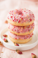 pink donuts in a plate, a tower of donuts
