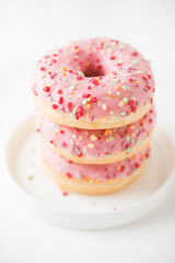 Pink donuts with fudge in a plate, selective