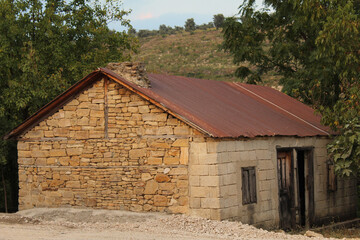 an old abandoned tiny house made of yellow rocks