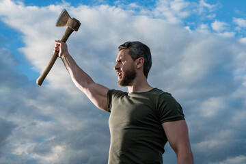 confident man with axe. strong caucasian man hold ax. brutal man on sky background