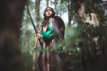 beautiful medieval girl archer in a forest