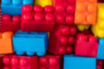 Defocused plastic colorful toy blocks for children game top close view. Education concept.
