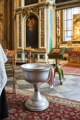 Orthodox font in the church for the baptism of the baby in front of the open altar