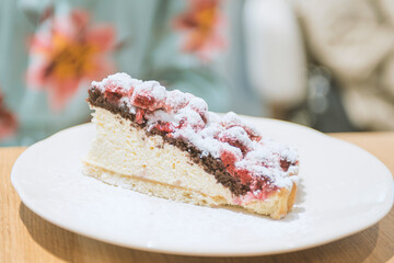 Closeup photo of woman eating piece of cake with raspberries