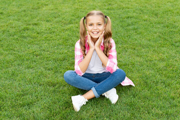 happy teen child sit on green grass outdoor