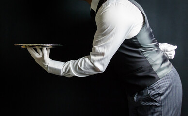 Portrait of Butler or Waiter in Vest and White Gloves Holding Silver Serving Tray. Concept of At Your Service. Professional Hospitality.