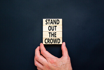 Stand out the crowd symbol. Concept words Stand out the crowd on wooden blocks on beautiful black...