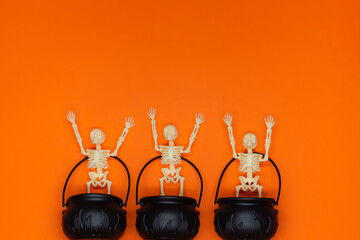 Three skeletons with their arms raised crammed into pots of boiling food. Halloween parties. Day of...