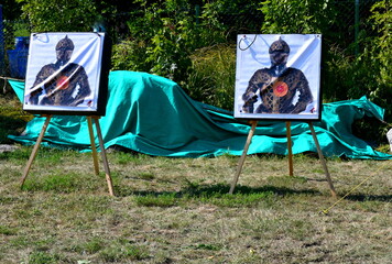 A close up on three targets used for arrow shooting practice hanging from ropes or strings and...