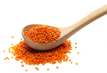 Red lentils pile in wooden spoon  isolated on white  