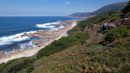 AERIAL VIEW - Summer Atlantic Ocean rocky coast landscape in the autonomous community of Galicia, Spain. Rocky coast with sea waves beating.
