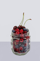 berries in a glass jar cherries, raspberries, blueberries