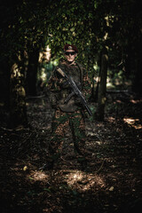Fototapeta premium Portrait of an eastern special forces soldier with rifle in woodland