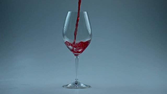 Intoxicant beverage filling goblet slow motion. Rose jet streaming container