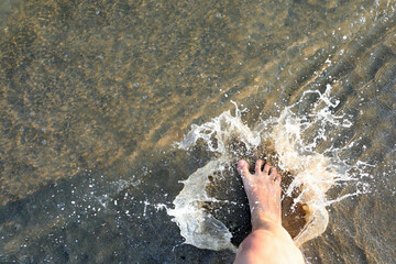 splashes of sea water and the foot of the person