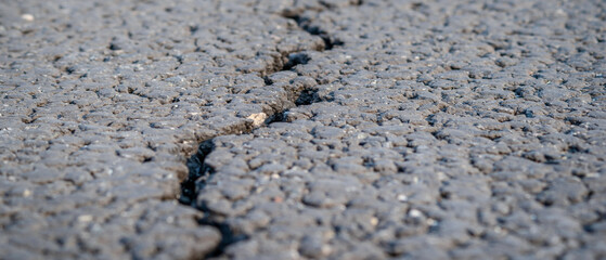 terrible crack in the road pavement, close up blurry background